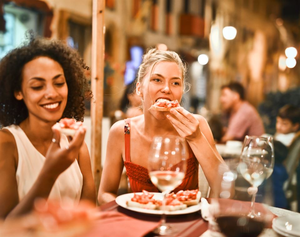 Guía Maestra: Cómo Multiplicar tus Ingresos con Upselling y Cross-Selling en tu Alquiler Vacacional 12 mujeres-cenando-restaurante