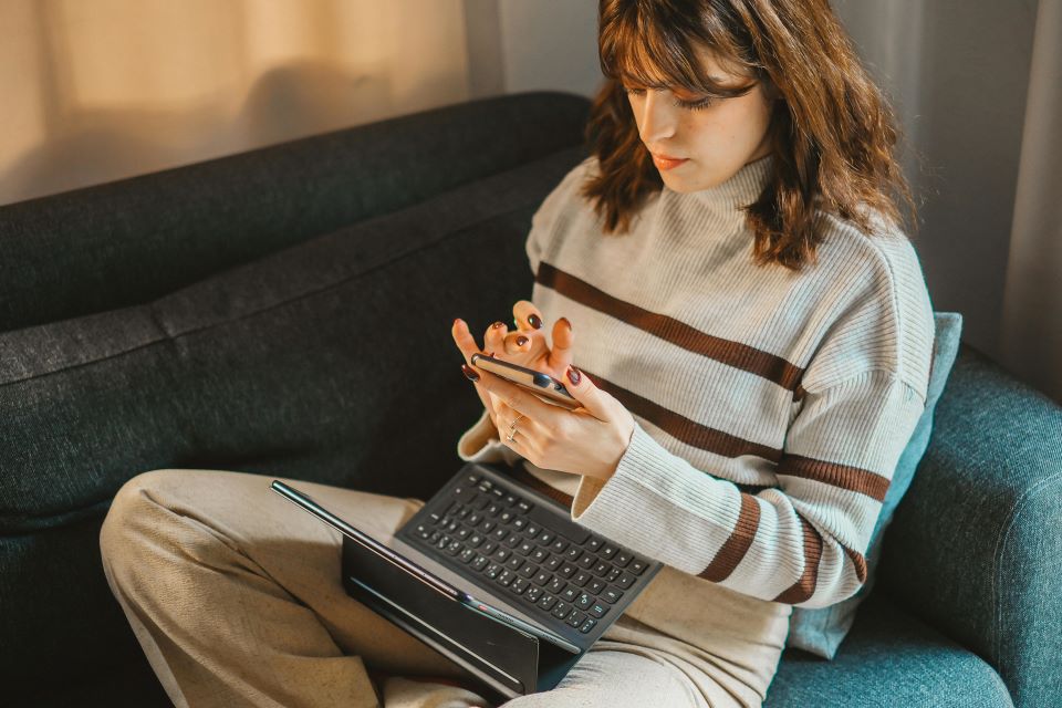 Cómo gestionar las reservas de tu alojamiento de forma eficaz 4 mujer-mira-movil-y-ordenador
