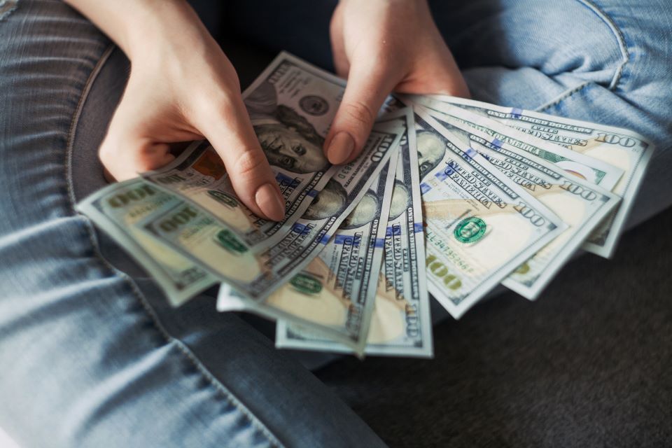 mujer-sostiene-billetes-de-dolares-en-la-mano