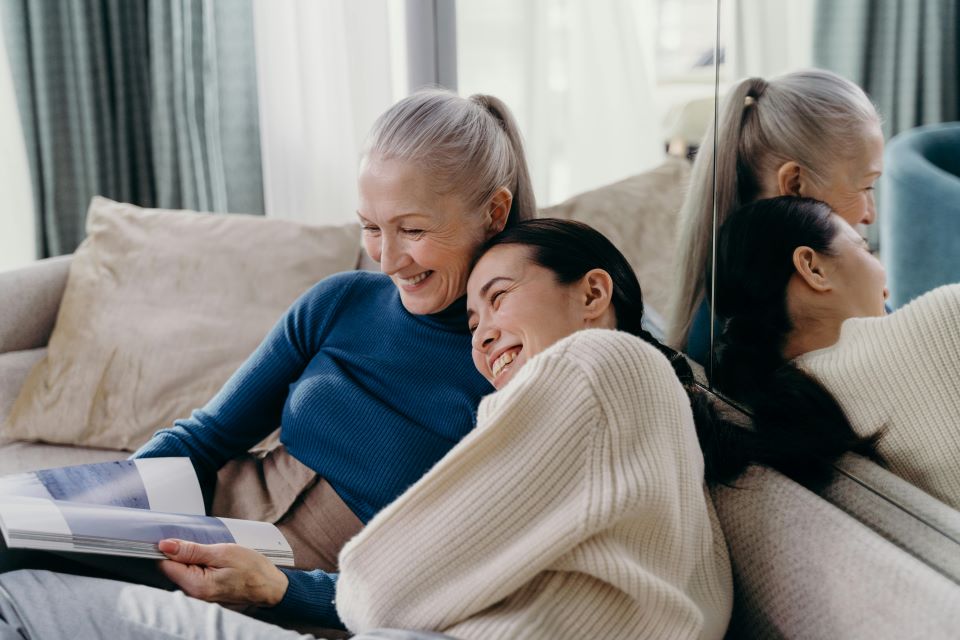 Guía Maestra para Maximizar la Rentabilidad y el Éxito de tu Alquiler Vacacional 11 dos-mujeres-riendose-sentadas-sofa